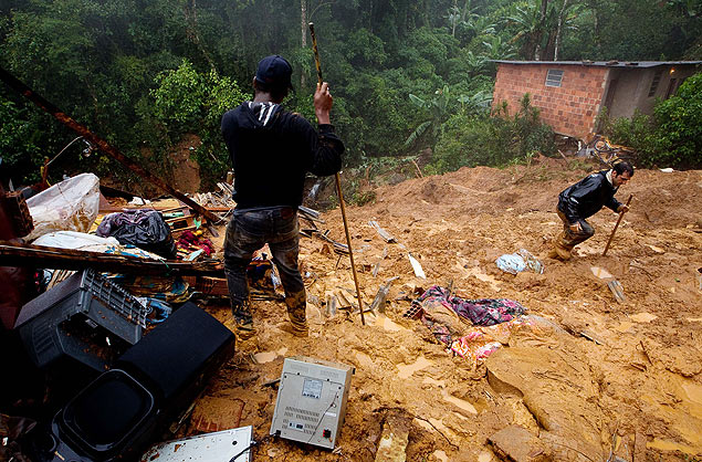 Moradores buscam por desaparecidos após chuva causar deslizamento de terra na região serrana do RJ